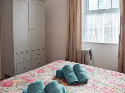 a bedroom with a bed with blue pillows on it at Seadrift in New Quay