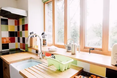 a kitchen with a sink and two windows at The Barn at Ty Beic in Bala