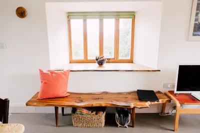 a room with a wooden table and a window at The Barn at Ty Beic in Bala