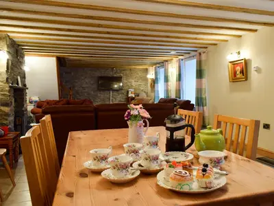 a wooden table with tea cups and saucers on it at Penrhiw in Llangeitho