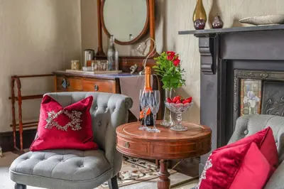 a living room with two chairs and a table at Afon Rhaiadr Country House in Dolgellau