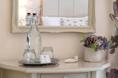 a table with two bottles and a mirror at Afon Rhaiadr Country House in Dolgellau