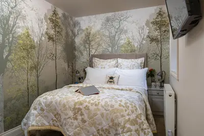 a bedroom with a bed with a book on it at Afon Rhaiadr Country House in Dolgellau