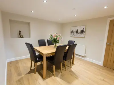 a dining room with a wooden table and black chairs at Minafon in Llangollen