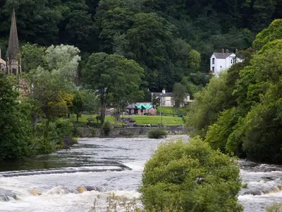 a river with a town in the background at Hafan in Llangollen