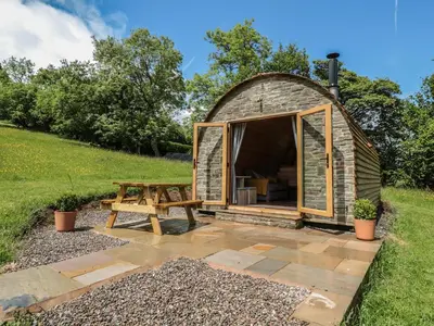 a shed with a picnic table and a bench at Dingle Den in Hereford