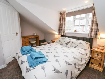 a bedroom with a bed with blue towels on it at Fisher Granary in Lampeter