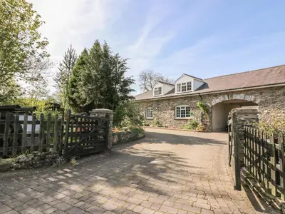 an entrance to a brick house with a wooden gate at Fisher Granary in Lampeter