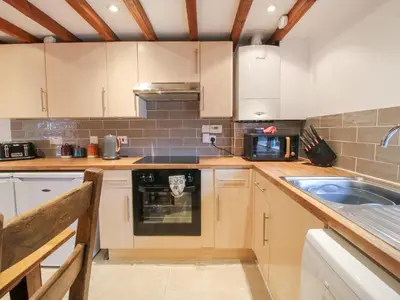 a kitchen with white cabinets and a sink at Old Hall Barn 4 in Church Stretton
