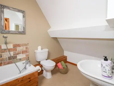 a bathroom with a sink toilet and a mirror at Old Hall Barn 4 in Church Stretton