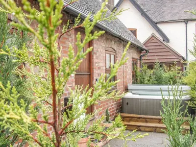 a brick house with a garden in front of it at Old Hall Barn 4 in Church Stretton
