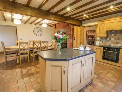 a kitchen with a table and a vase of flowers at Ty Berllan in Caersws