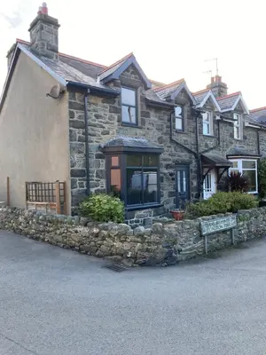 a stone house with a stone wall at Heulwen in Barmouth