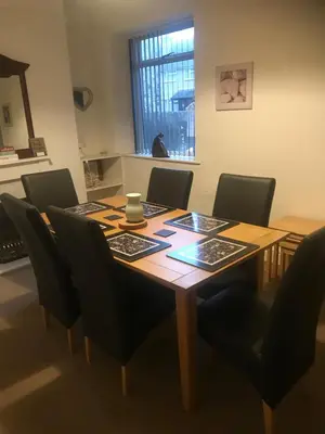 a dining room table with black chairs and a wooden table at Heulwen in Barmouth