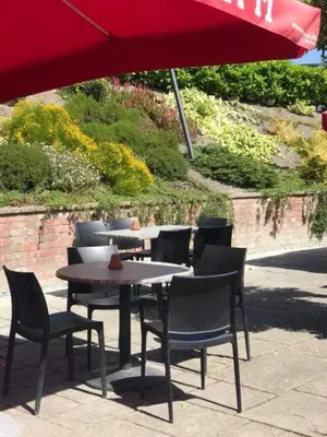 a table and chairs under a red umbrella at The Nags Head in Montgomery