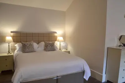 a bedroom with a large white bed with two lamps at The Nags Head in Montgomery