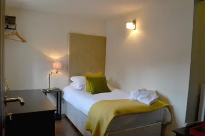 a bedroom with a bed with a yellow blanket on it at The Nags Head in Montgomery