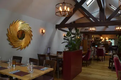 a dining room with tables and chairs and chandeliers at The Nags Head in Montgomery