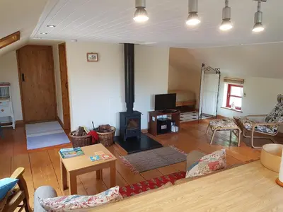 a living room with a wood stove in it at Seren Loft - Cynghordy, Llandovery in Llandovery