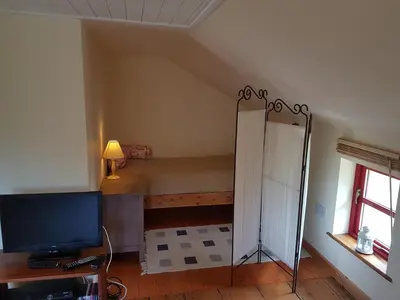 a living room with a television and a room with a bed at Seren Loft - Cynghordy, Llandovery in Llandovery