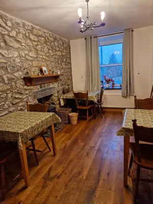 a living room with wooden floors and a stone wall at Maes y Gwaelod in Llanwrtyd Wells