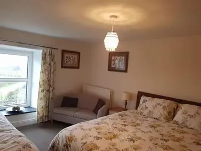 a bedroom with a bed and a window and a couch at Maes y Gwaelod in Llanwrtyd Wells