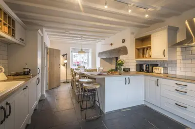 a kitchen with white cabinets and a counter at Finest Retreats - Tegannedd - Luxury Grade II Listed Cottage With Hot Tub in Ffestiniog