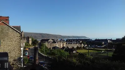 a view of a town with buildings and the ocean at Apartment Chic in Barmouth