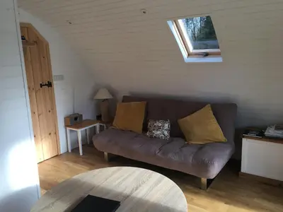 a living room with a brown couch and a window at Brynllwyd Glamping in Devils Bridge