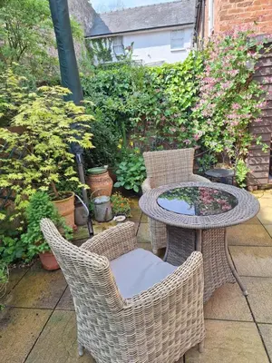 a patio with a table and chairs and plants at 19 Upper Linney in Ludlow