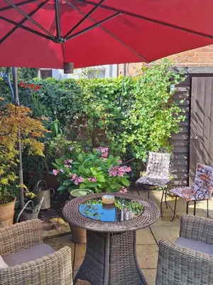 a patio with a table with a red umbrella at 19 Upper Linney in Ludlow
