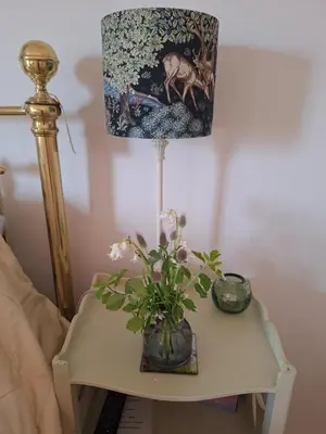 a table with a lamp and a vase with flowers on it at 19 Upper Linney in Ludlow