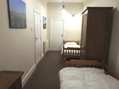 a small room with a bed and a room with a crib at Hawen - Barmouth in Barmouth