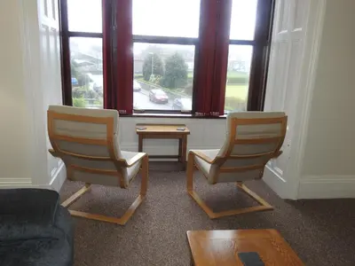 a living room with two chairs and a window at Hawen - Barmouth in Barmouth