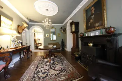 a living room with a table and a fireplace at Plas Esgair in Llanbrynmair