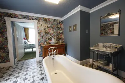 a bathroom with a tub and a sink at Plas Esgair in Llanbrynmair