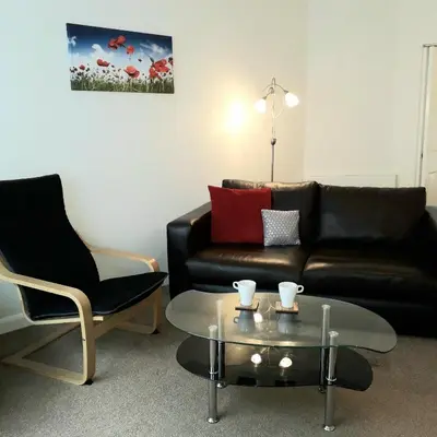 a living room with a leather couch and a coffee table at Lucea Cottage in Craven Arms