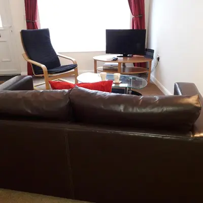 a living room with a brown leather couch and chairs at Lucea Cottage in Craven Arms