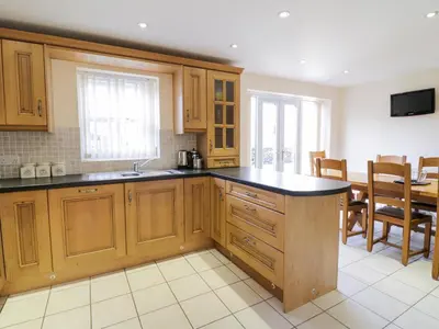a kitchen with wooden cabinets and black counter tops at Tyn Y Buarth in Dyffryn