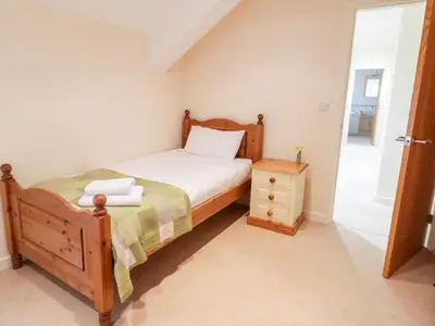 a bedroom with a bed and a wooden bed frame at Tyn Y Buarth in Dyffryn