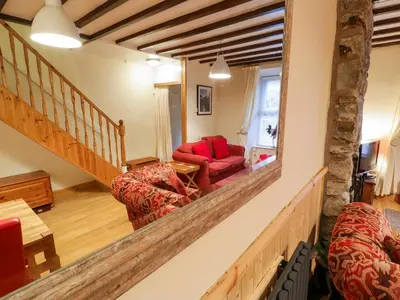 a living room with a staircase and red furniture at Edrydd in Harlech