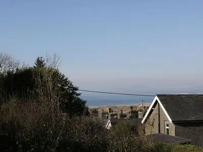 a house with a hill in the background at Edrydd in Harlech