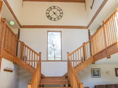 a large spiral staircase with a clock on the wall at The Stables in Knighton