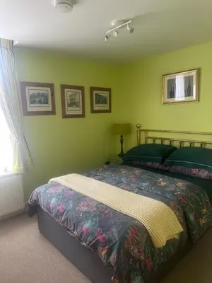 a bedroom with a bed and green walls at Flat G, 8 Castle Street in Ludlow