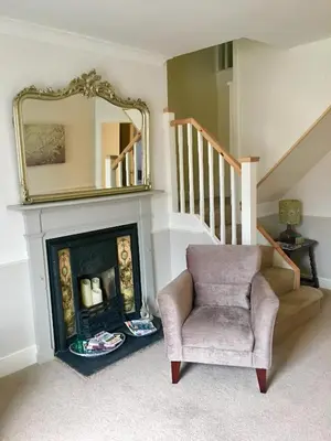 a living room with a chair and a fireplace at Beautiful stylish 2 bed apartment with free parking in Ludlow