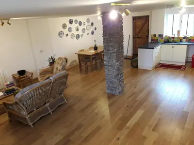 a living room with a stone pillar and a table at The Barn Annexe, Cefn-Yr-Allt in Crickadarn