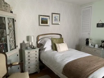a bedroom with a bed and a dresser with a lamp at Evangelisa in Lampeter