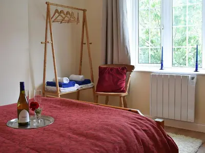 a bedroom with a bed with a bottle of wine and a chair at Glasfor in Llanon