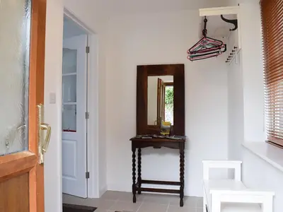 a hallway with a mirror and a wooden table at Glasfor in Llanon