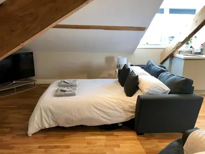 a bedroom with a bed and a couch and a television at Apartment 4, 1 Laura Place in Aberystwyth